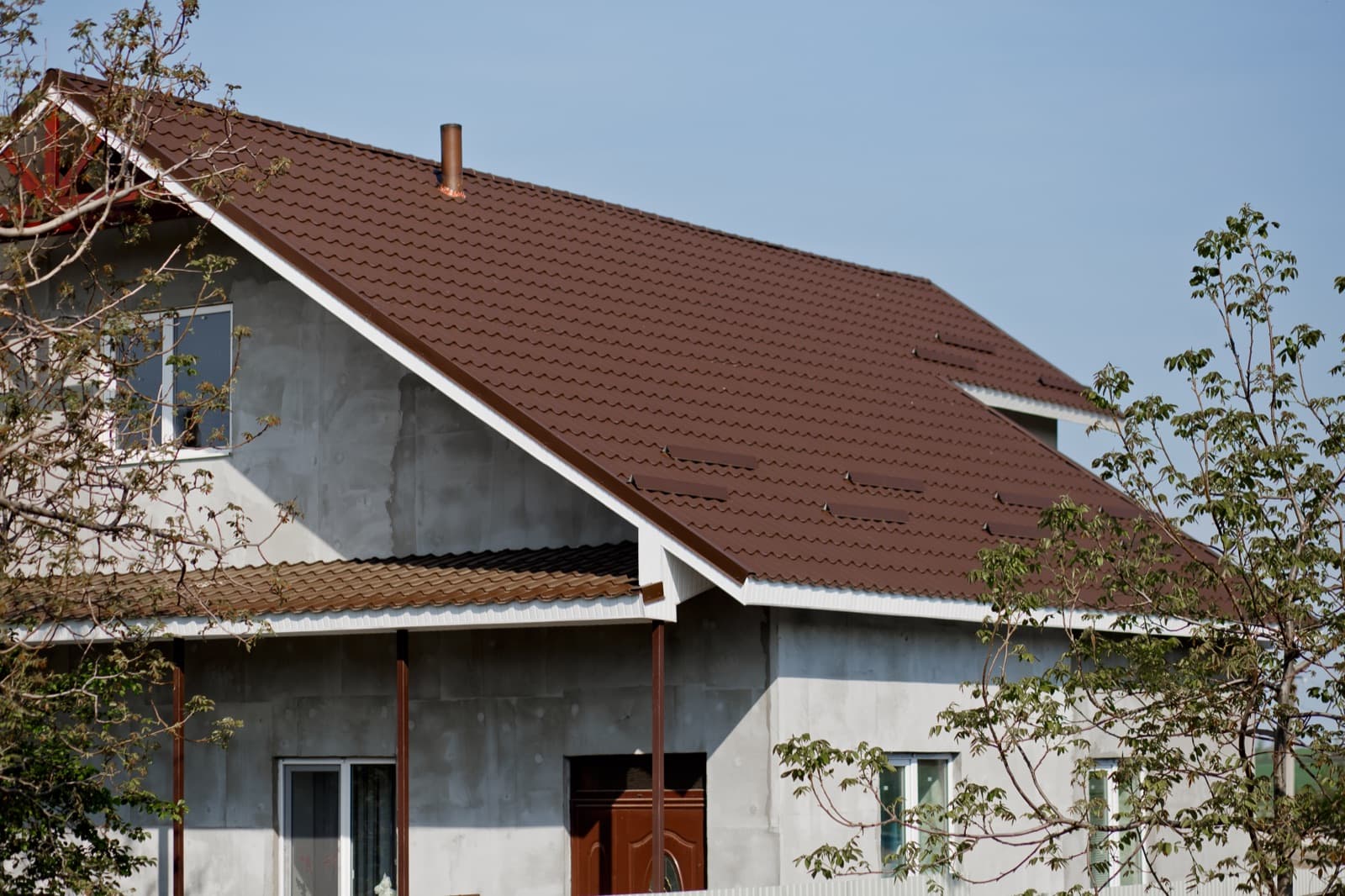 Țiglă metalică brună montată pe acoperiș înclinat