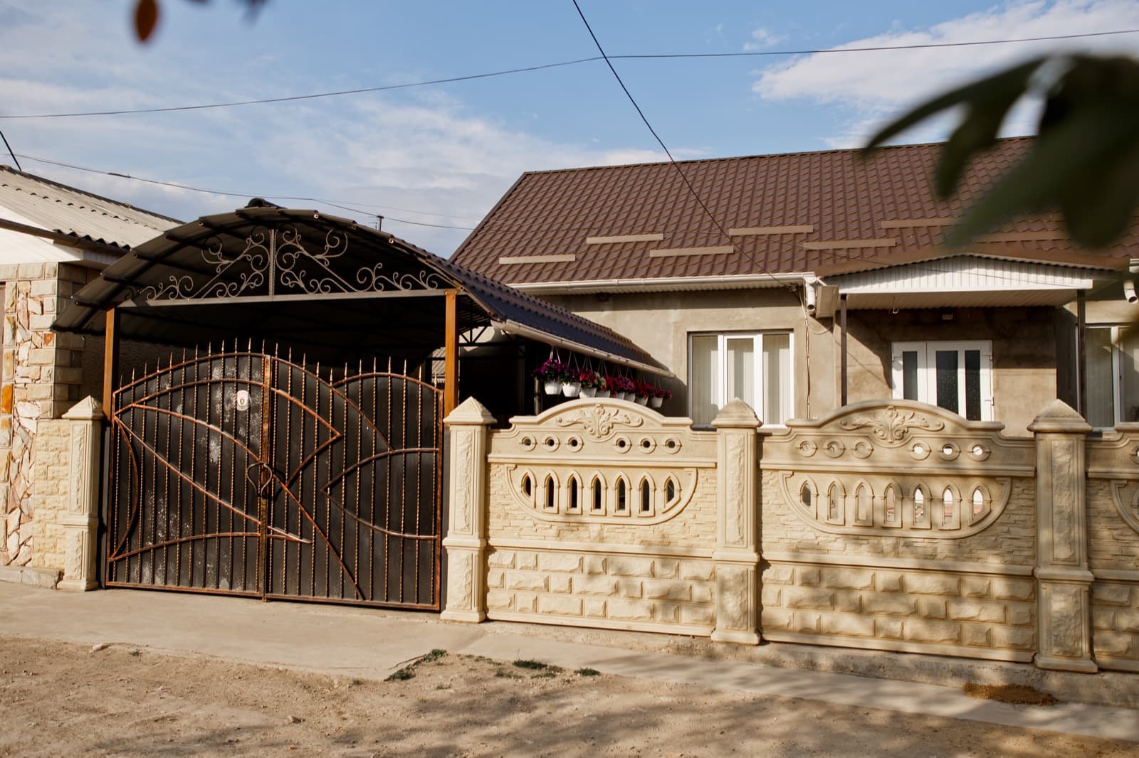 Casă cu acoperiș metalic brun și copertină finisată în aceeași familie de culoare